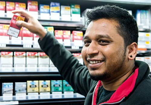 Shop keeper reaching for a cigarette packet