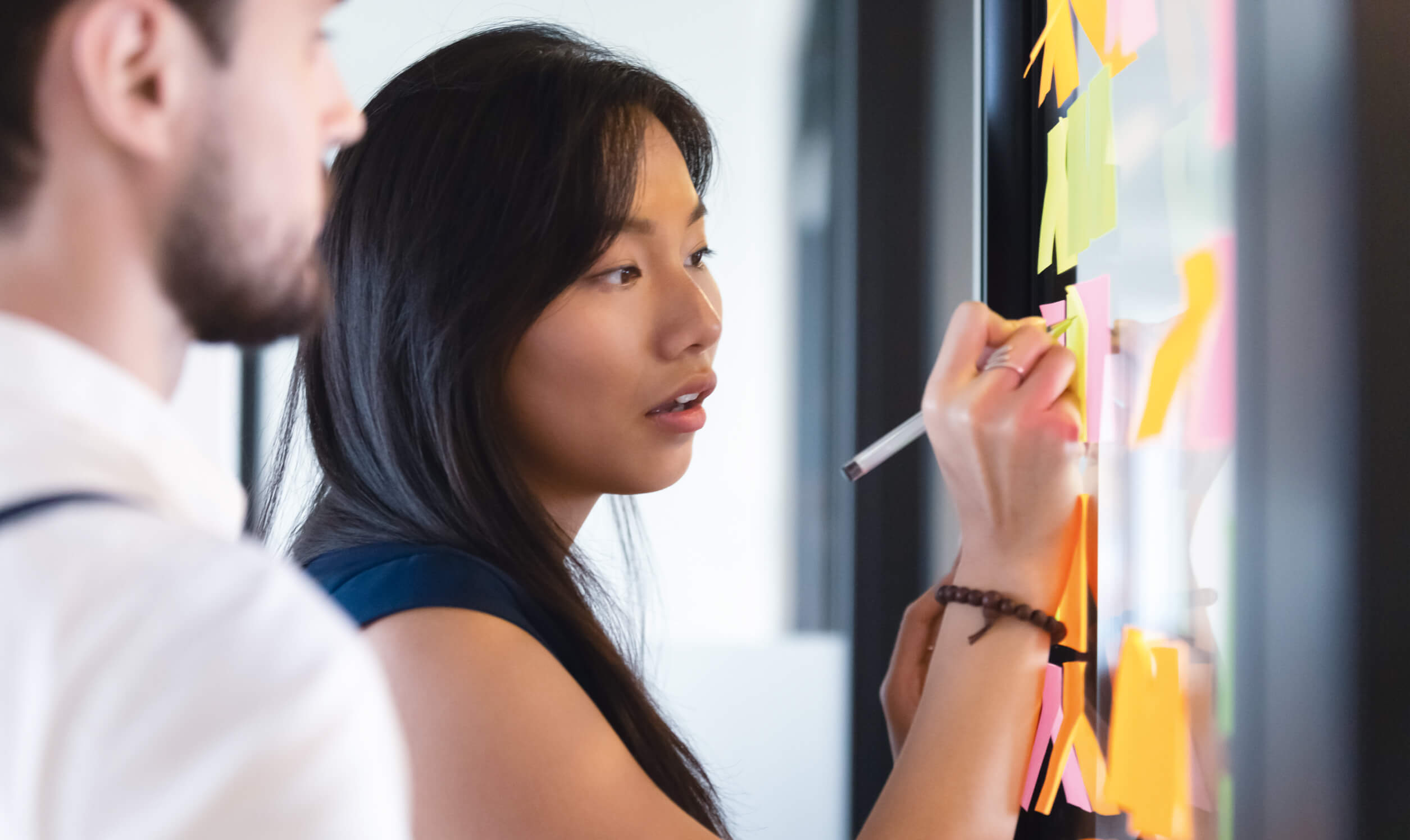 a woman drawing on a whiteboard