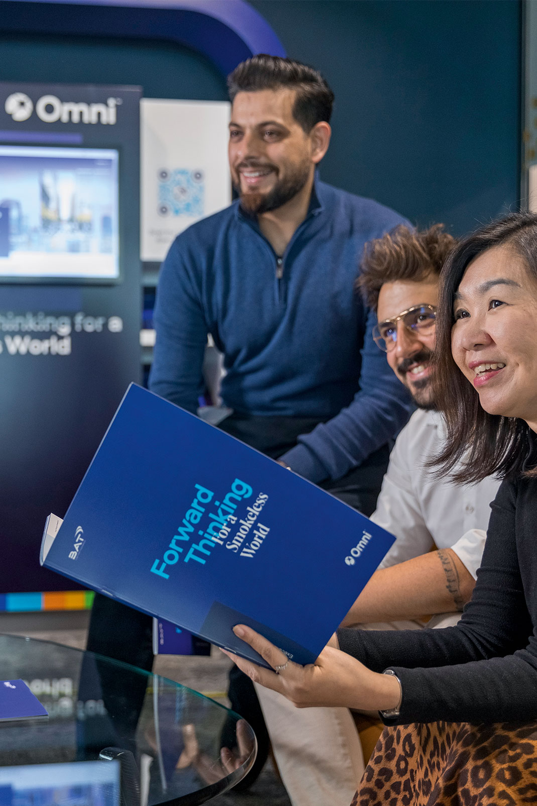 A group of employees smiling sitting around a table