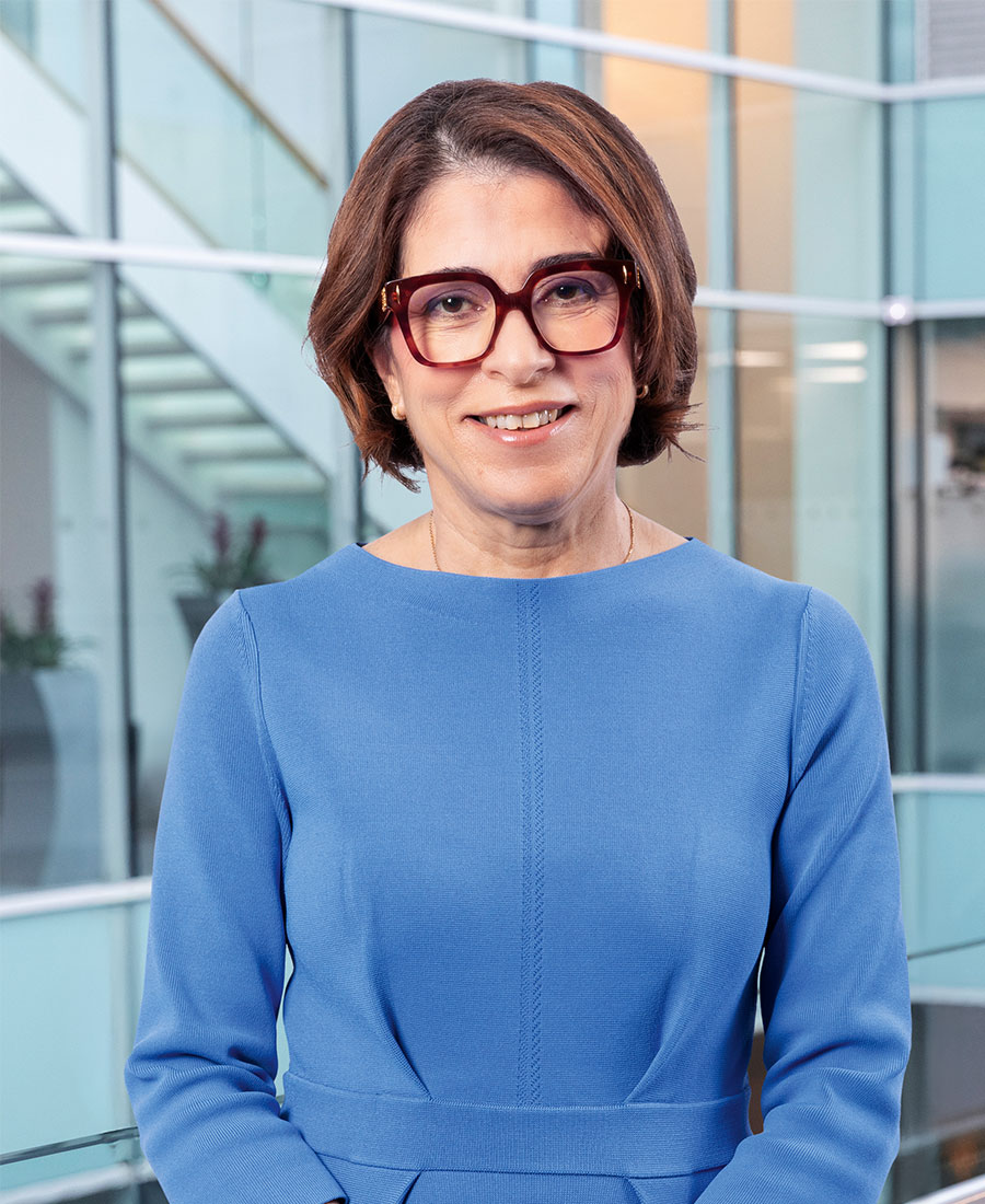 Soraya wearing a blue dress smiling for the camera