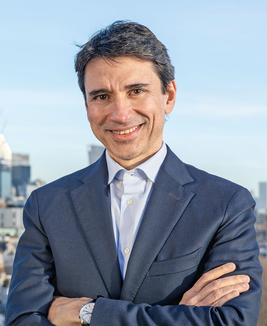 Tadeu wearing a suit and smiling for the camera