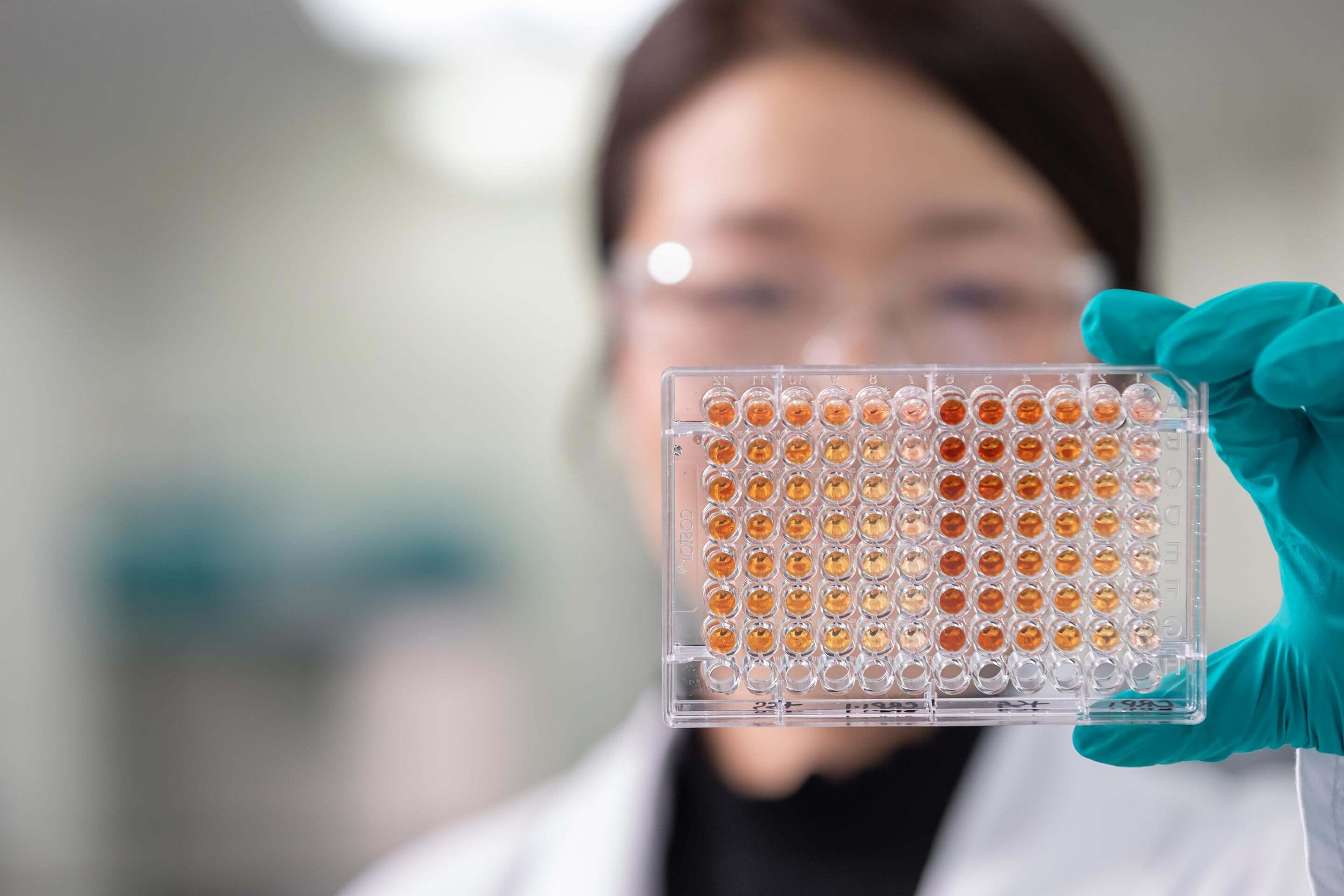 A female scientist holding up a tray of samples
